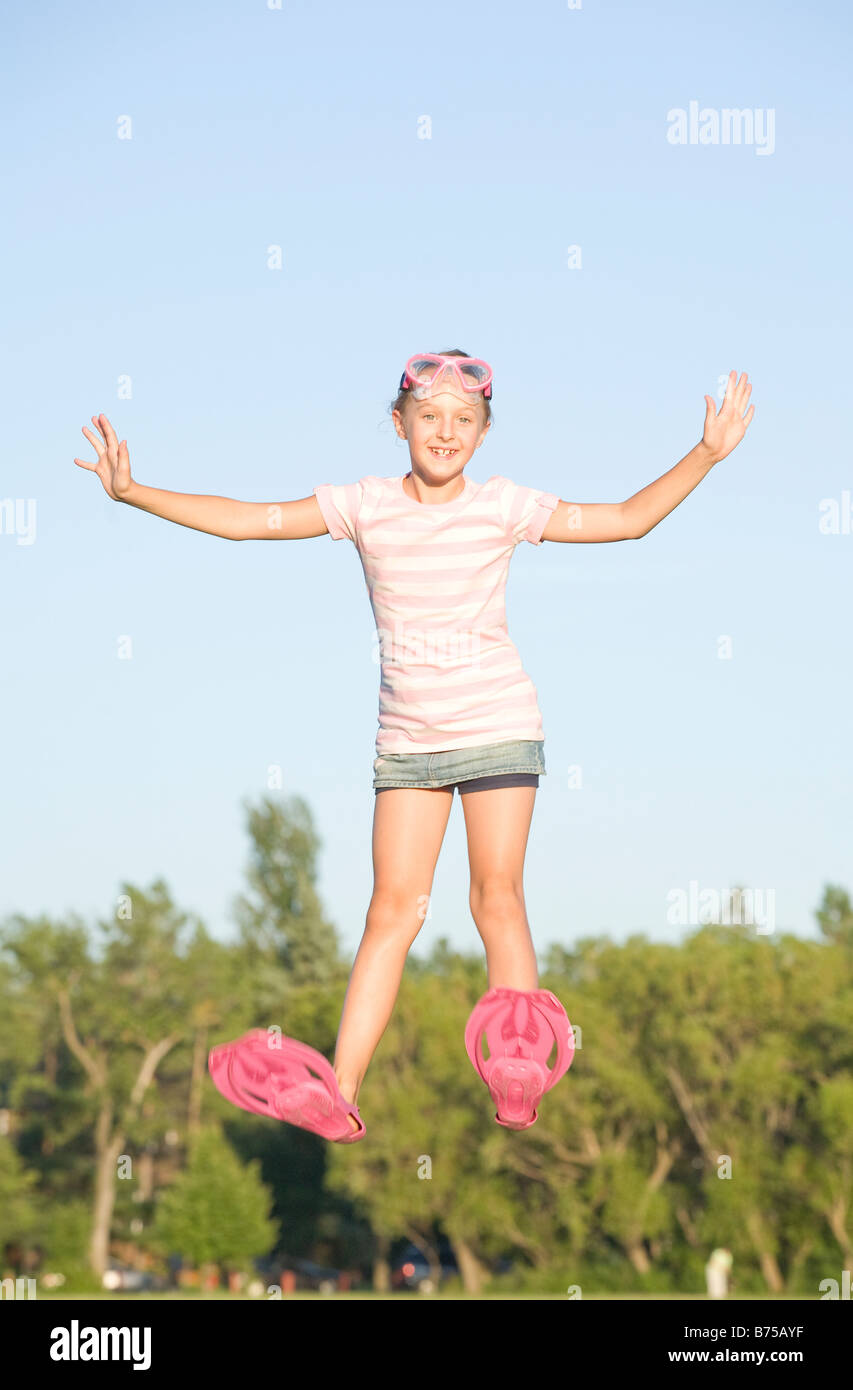 11 year old girl with swim fins jumping high, Winnipeg, Manitoba