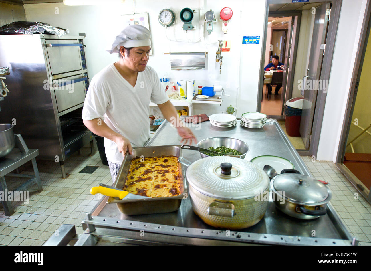 Cook preparing a meal in kitchen of a bulk carrier Stock Photo