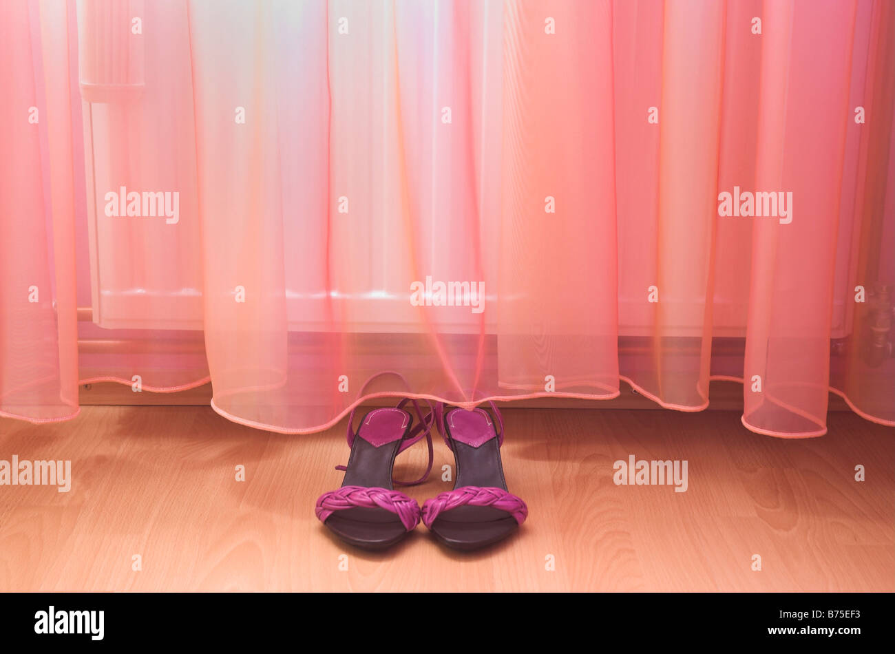Womans sandals on floor by curtain Stock Photo