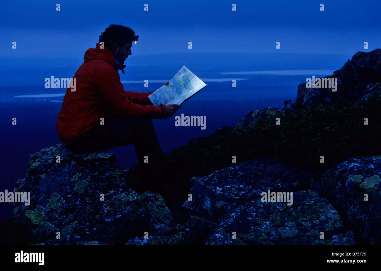 man with headlamp is reading lapland sweden Stock Photo