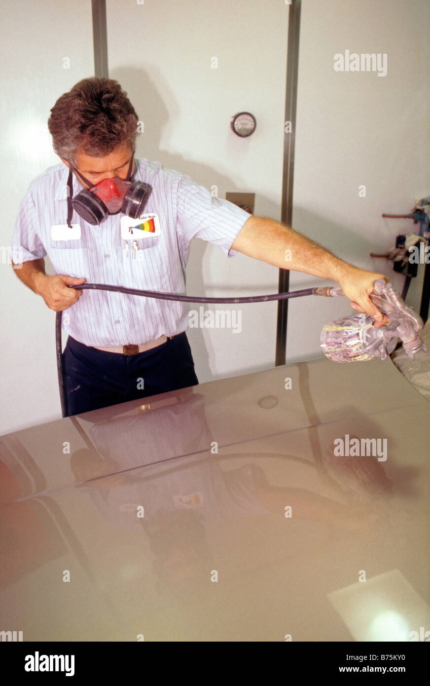 Auto Body Shop Spray Painter in Dust-free Booth painting hood. Stock Photo