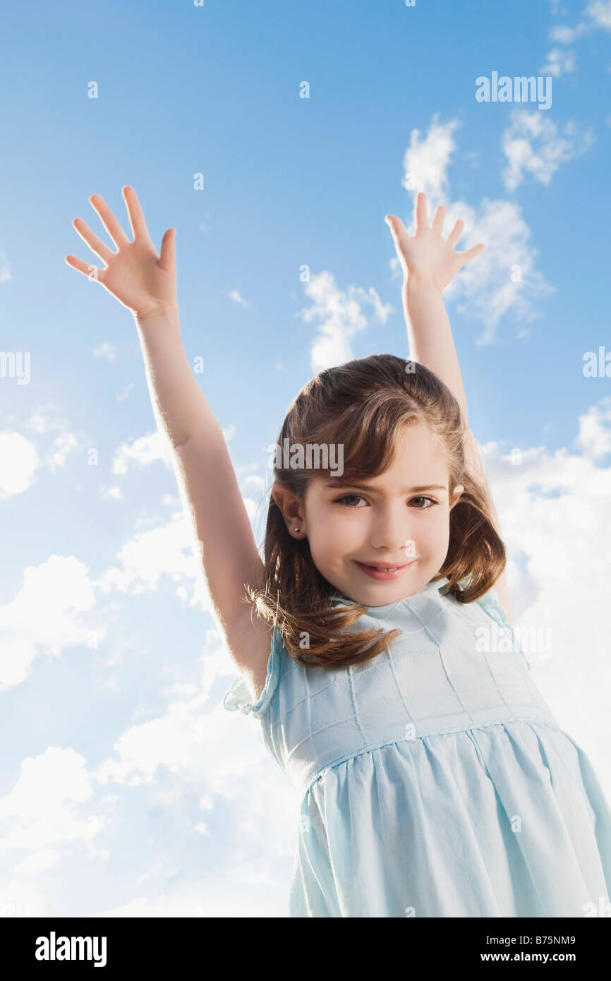Low angle view of a girl smiling with her arms raised Stock Photo - Alamy