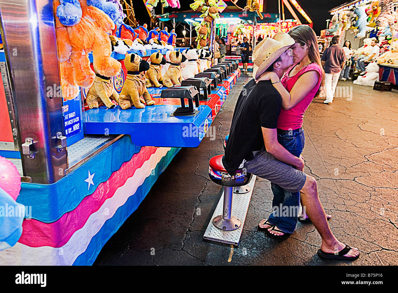 Teenage couple kissing each other in an amusement park Stock Photo - Alamy