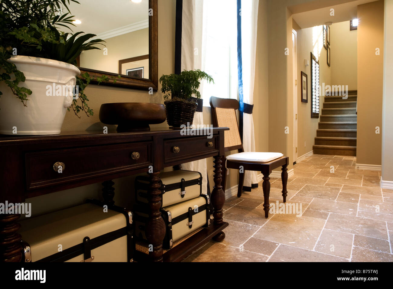 End table and chair in hallway below staircase Stock Photo Alamy