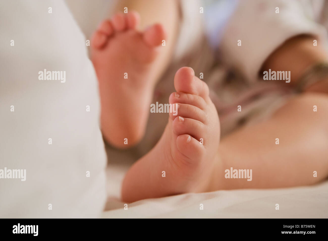 Low section view of a baby girl sitting on the bed Stock Photo - Alamy