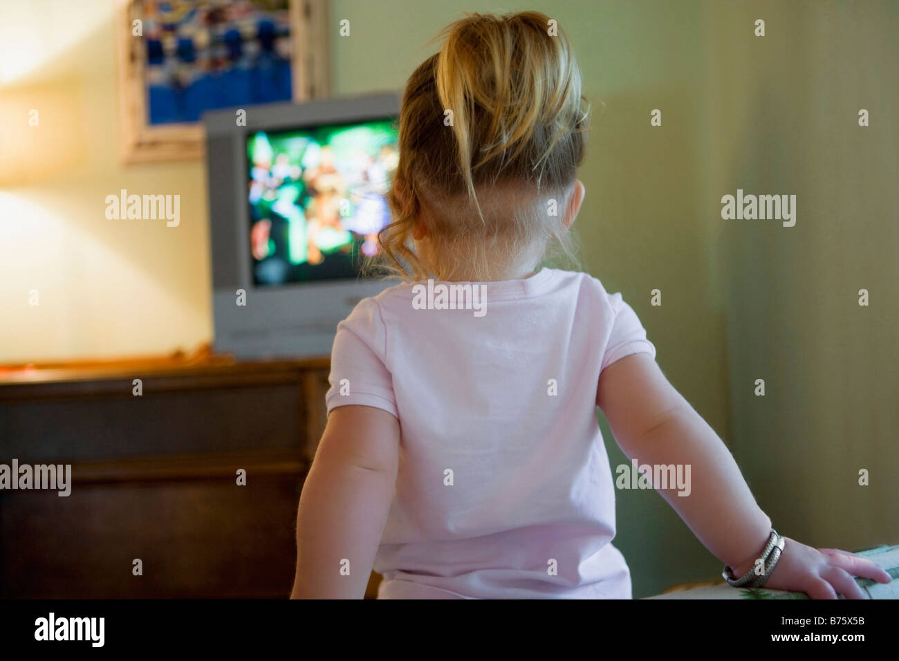 Rear view of a baby girl watching television Stock Photo