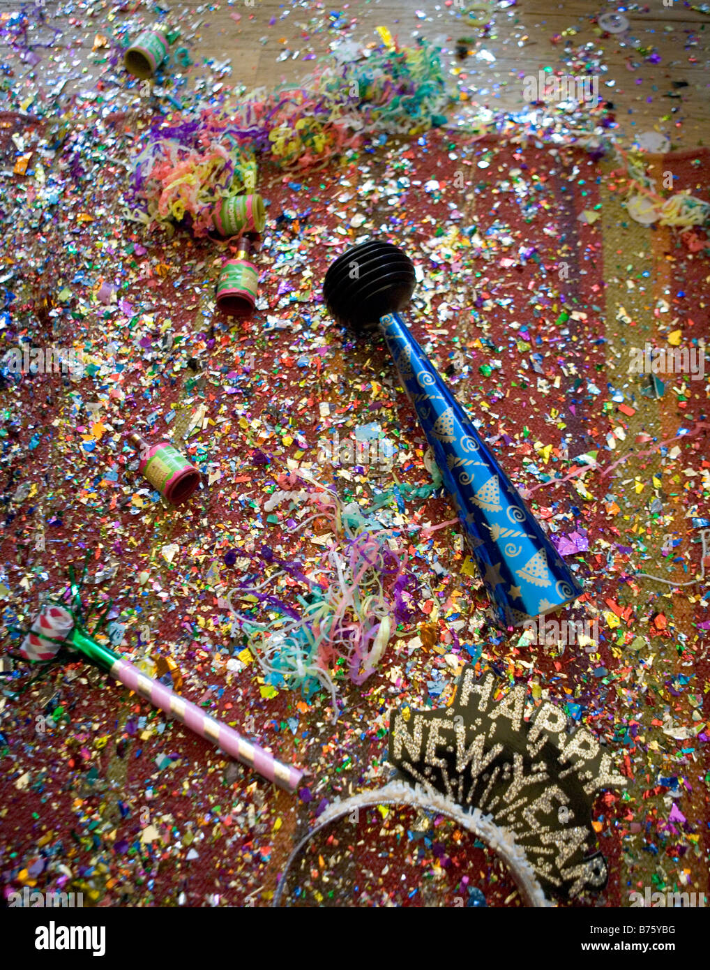 New Years Eve Party Wreckage including confetti poppers horns streamers and hats Stock Photo