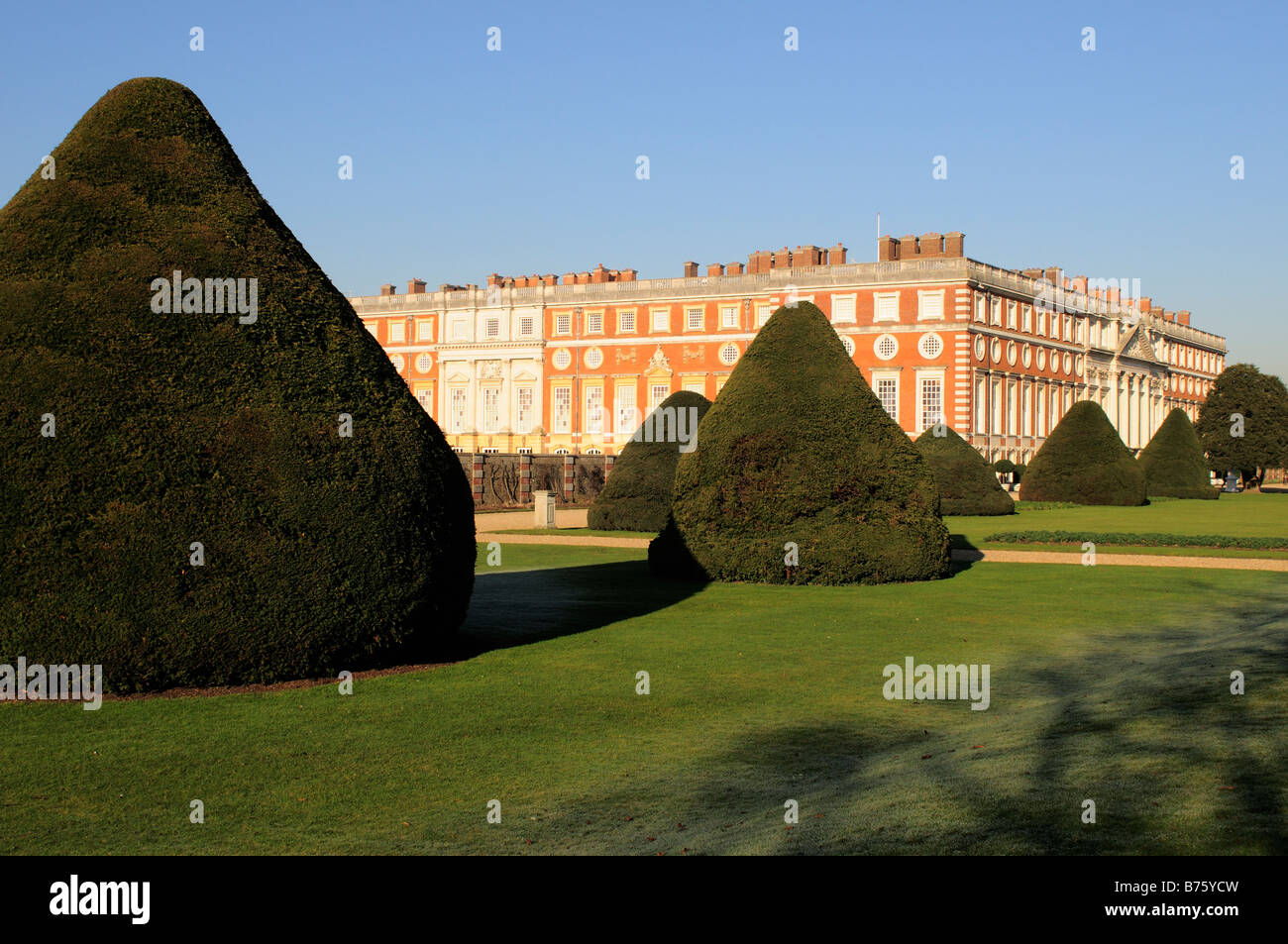 Hampton Court Palace and grounds with conically shaped yew trees Surrey Stock Photo