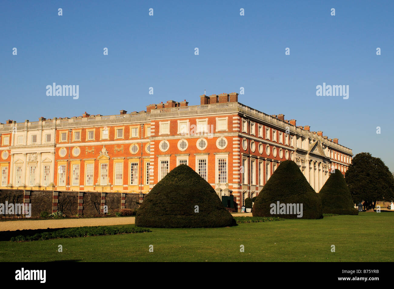 Hampton Court Palace and grounds with conically shaped yew trees Surrey Stock Photo