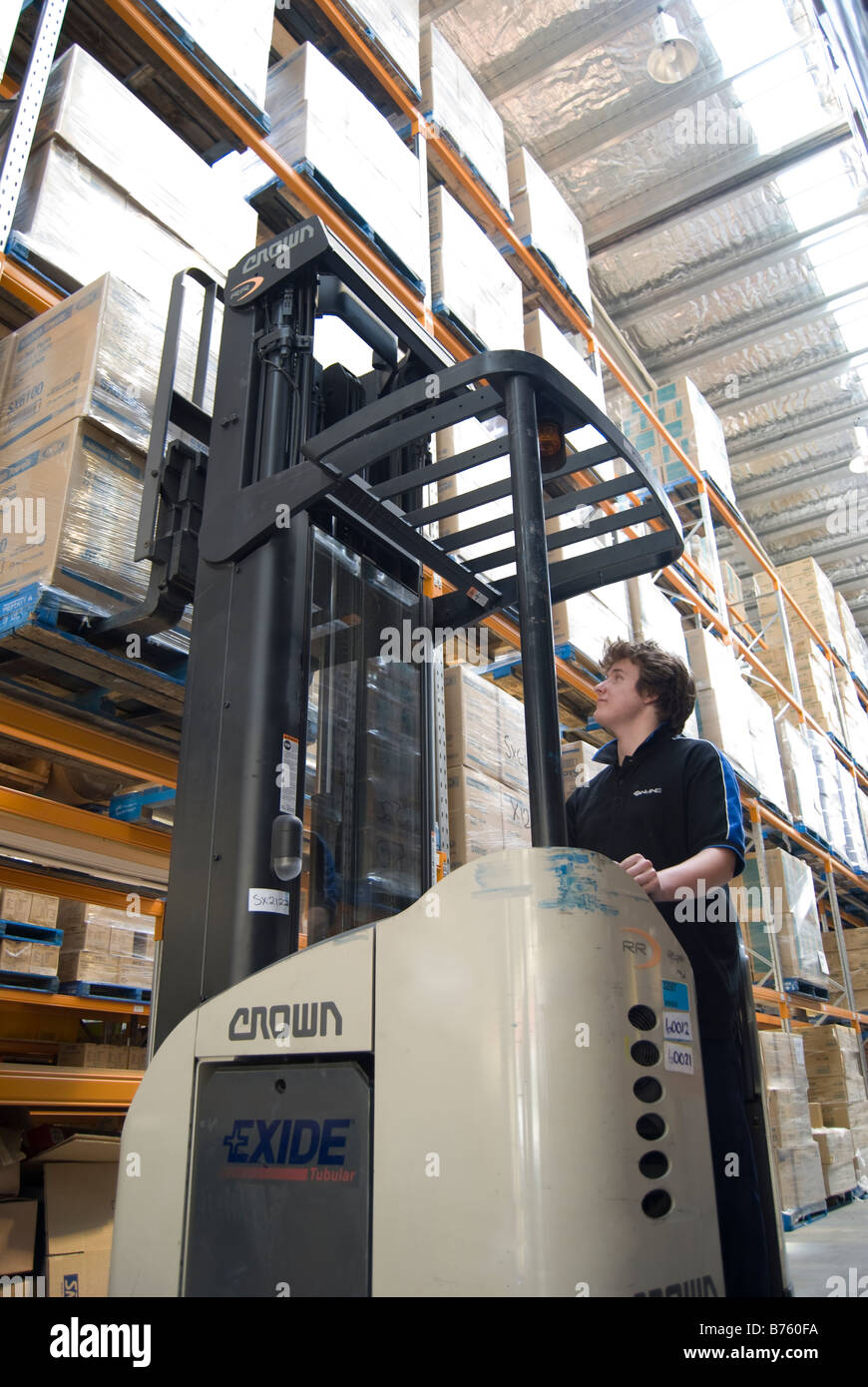 Young man using forklift in large warehouse, Online Distribution, Port Hills Road, Christchurch, Canterbury, New Zealand Stock Photo