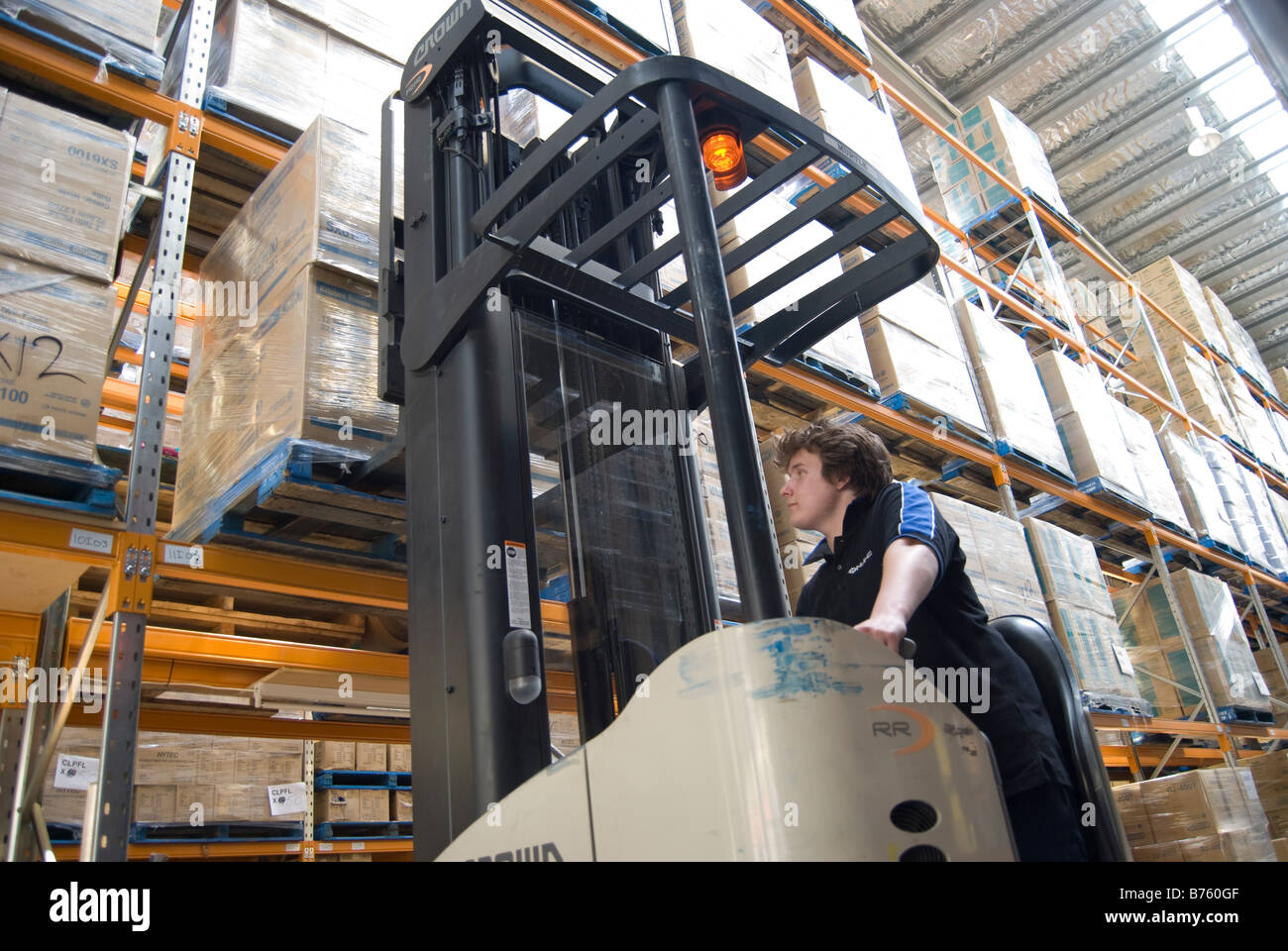 Young man using forklift in large warehouse, Online Distribution, Port Hills Road, Christchurch, Canterbury, New Zealand Stock Photo