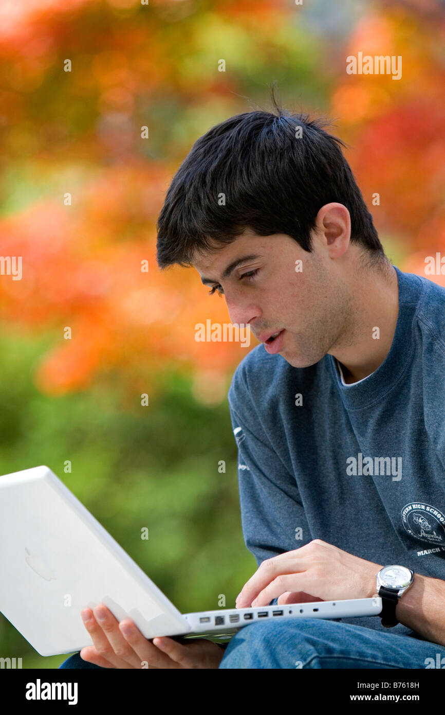 Male student studying with a laptop computer in Harvard Yard at Harvard University in Cambridge Greater Boston Massachusetts USA Stock Photo