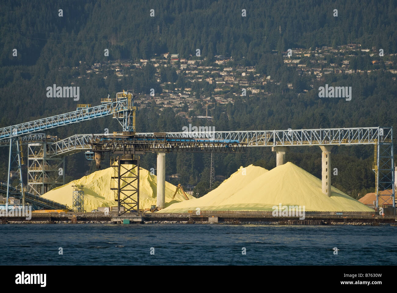Piles of bulk sulphur on a dock waiting for export from the port of Vancouver, Canada. Stock Photo