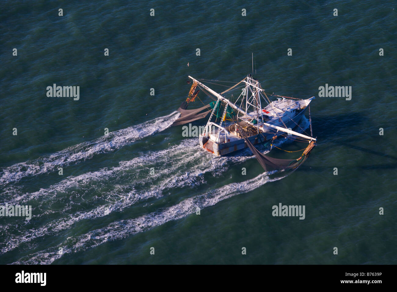 Aerial view of a shrimp boat nets dropped working the water off the coast of Charleston South Carolina Stock Photo