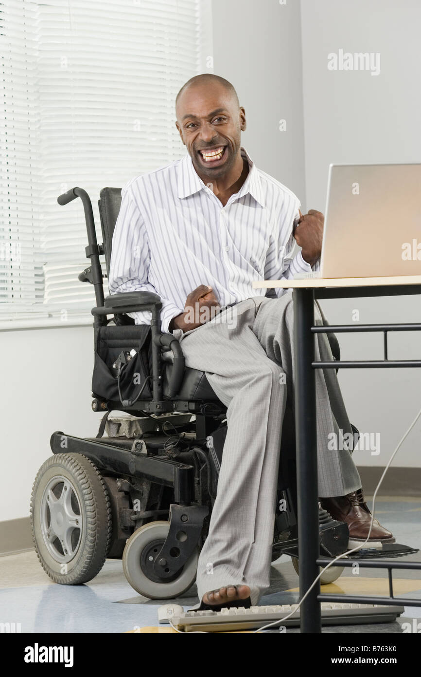 Portrait of a businessman with Cerebral Palsy sitting in a wheelchair and  working on a computer with his foot Stock Photo - Alamy