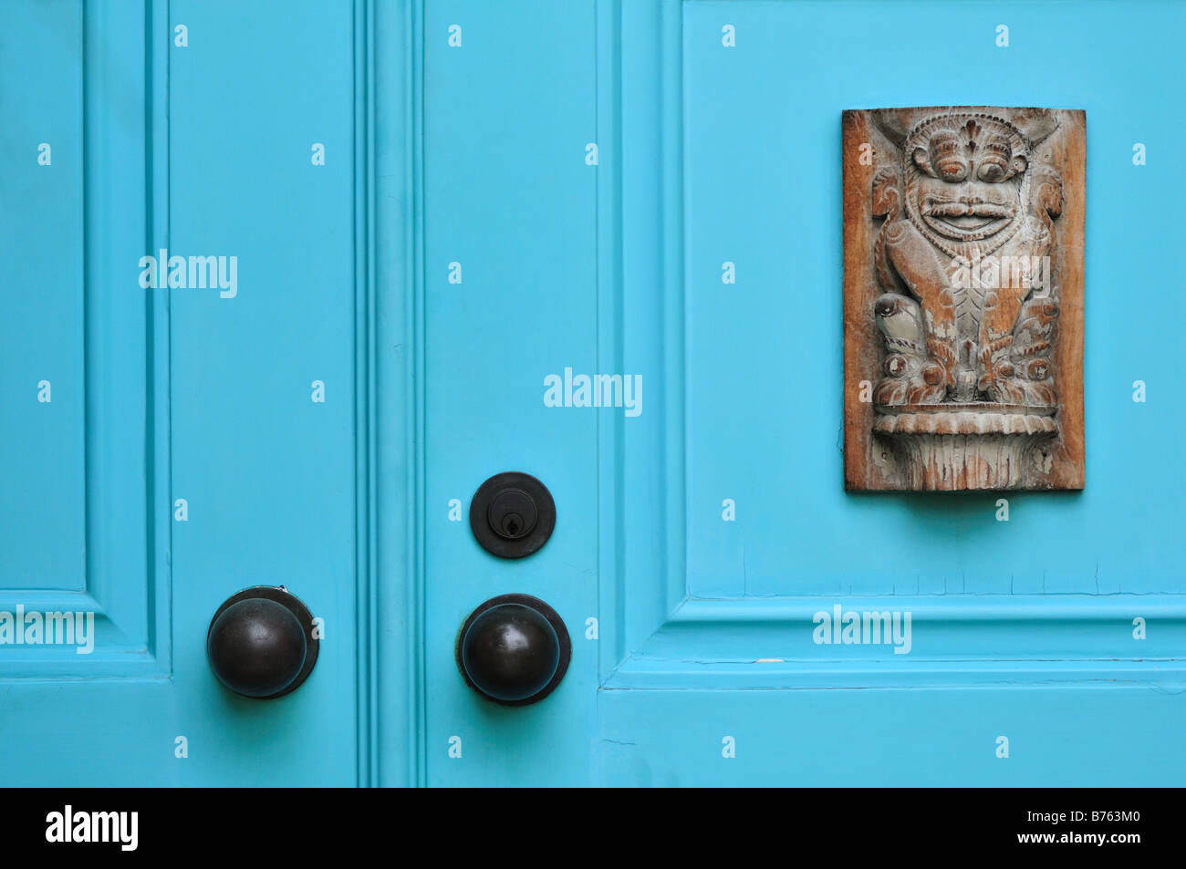 Light blue front doors with antique carved lion panel Stock Photo