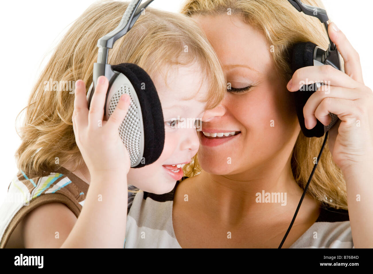 three year old boy and mother with headphones listening music Stock