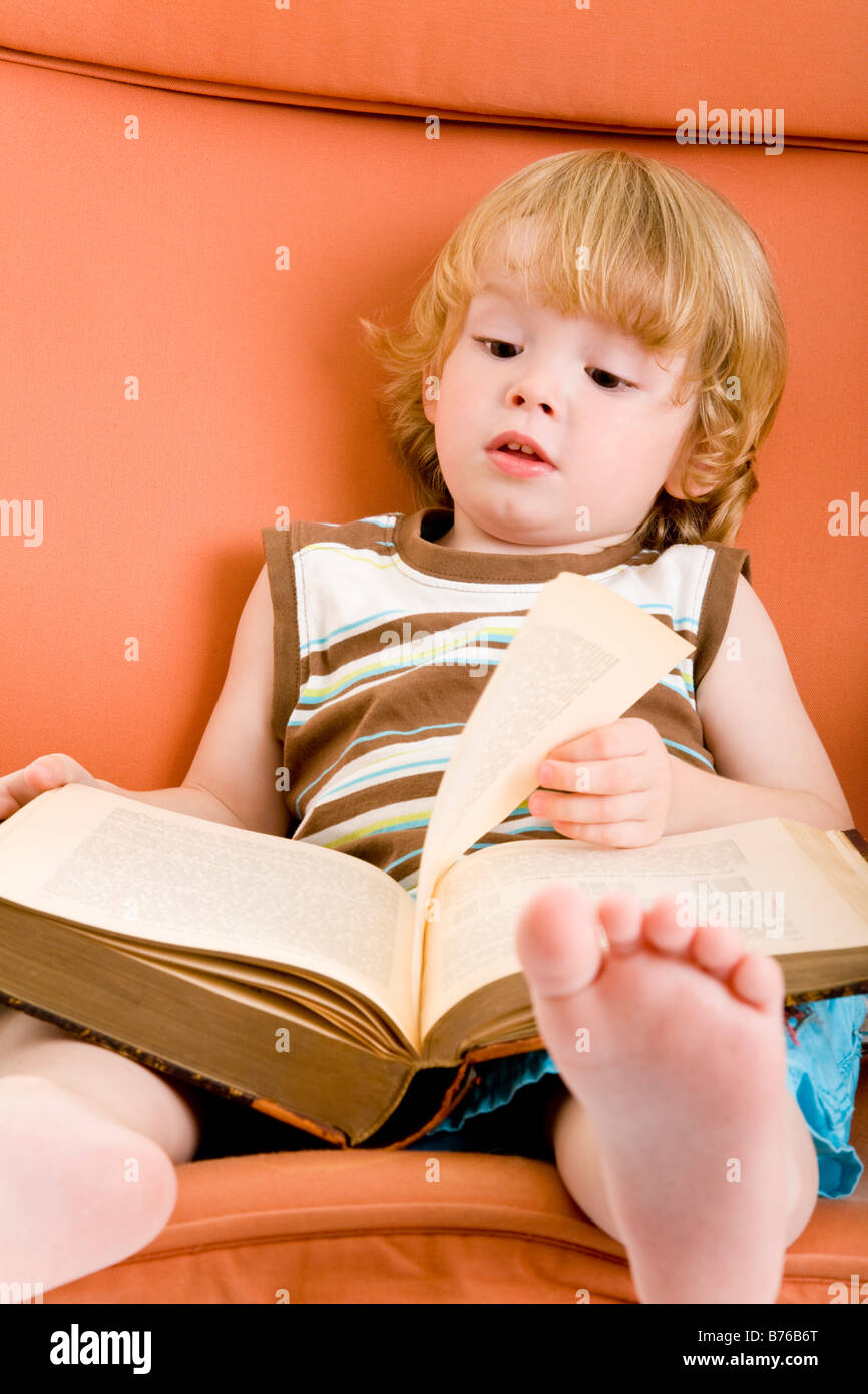 three year old boy reading a book Stock Photo