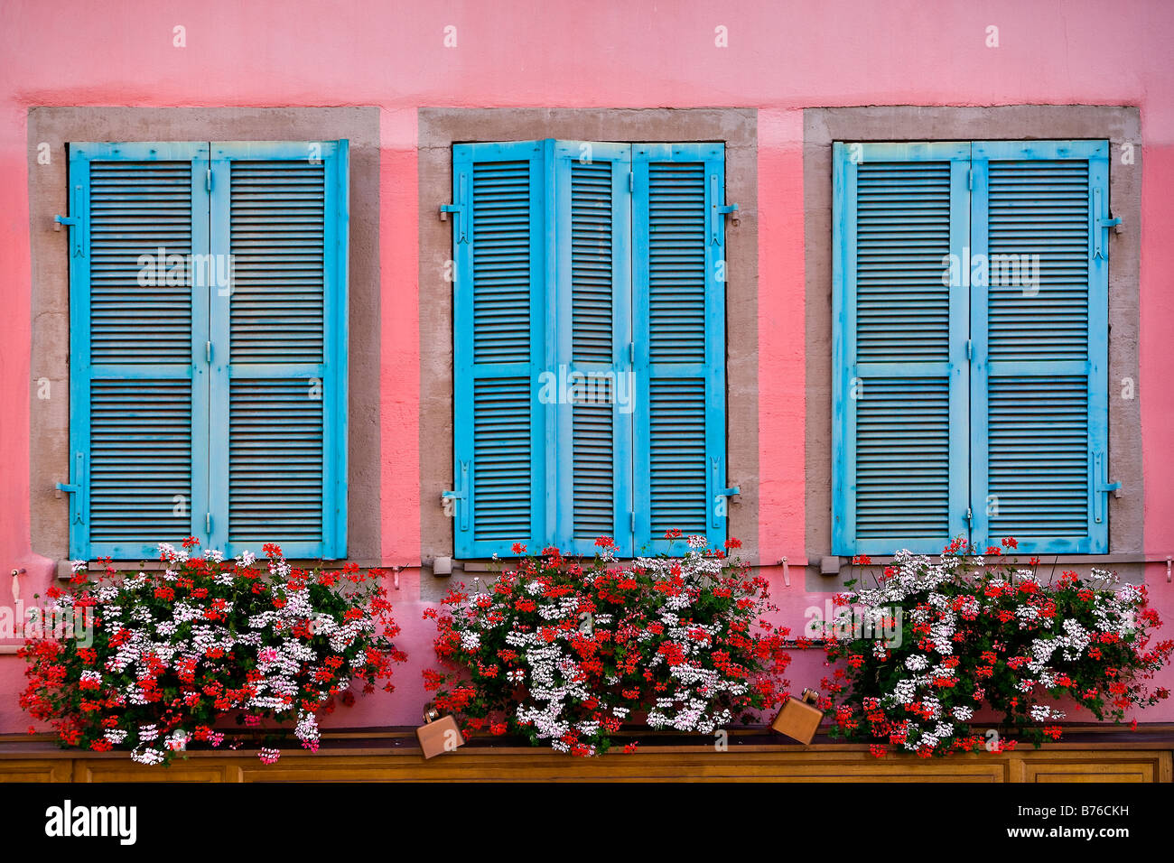 three windows with flowers and shutters Colmar Alsace France Europe Stock Photo