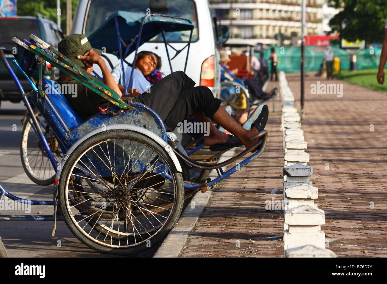 Sleeping Cyclo drivers having a nap in the streets of Phnom Penh, Cambodia South east Asia Stock Photo