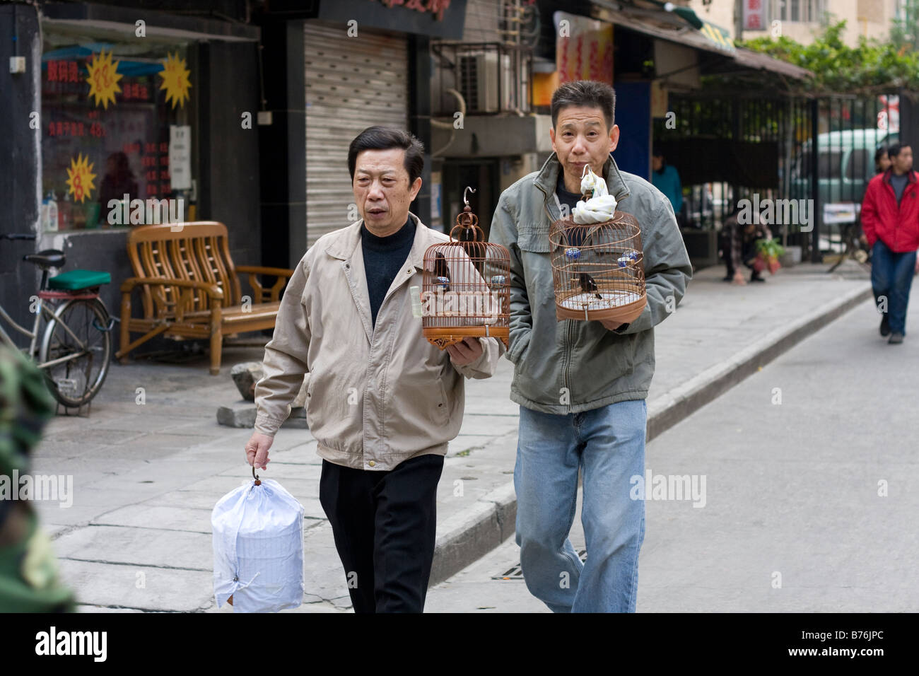 CHinese residents walking their birds inside traditional birdcage durring the first cold winter day in Guangzhou Guangdong China Stock Photo