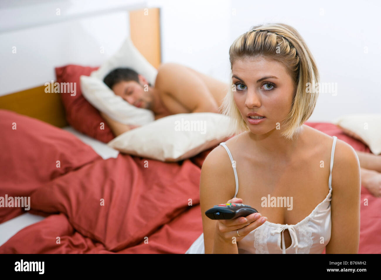 Gelangweilte Frau im Schlafzimmer ihr Mann schlaeft, Bored woman in the bedroom their man sleeps Stock Photo