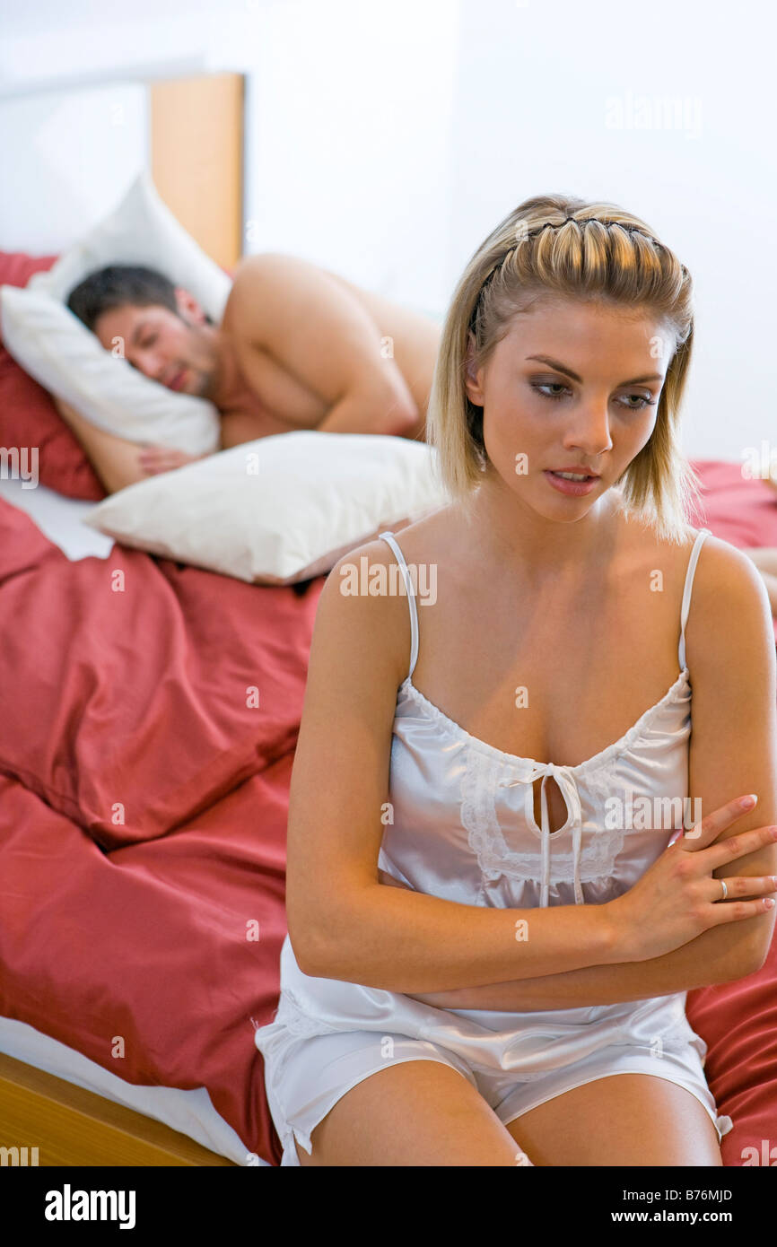 Gelangweilte Frau im Schlafzimmer ihr Mann schlaeft, Bored woman in the bedroom their man sleeps Stock Photo