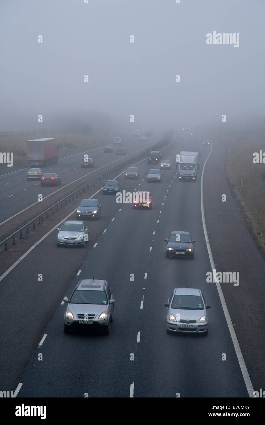 Cars and lorries on motorway in fog , uk Stock Photo