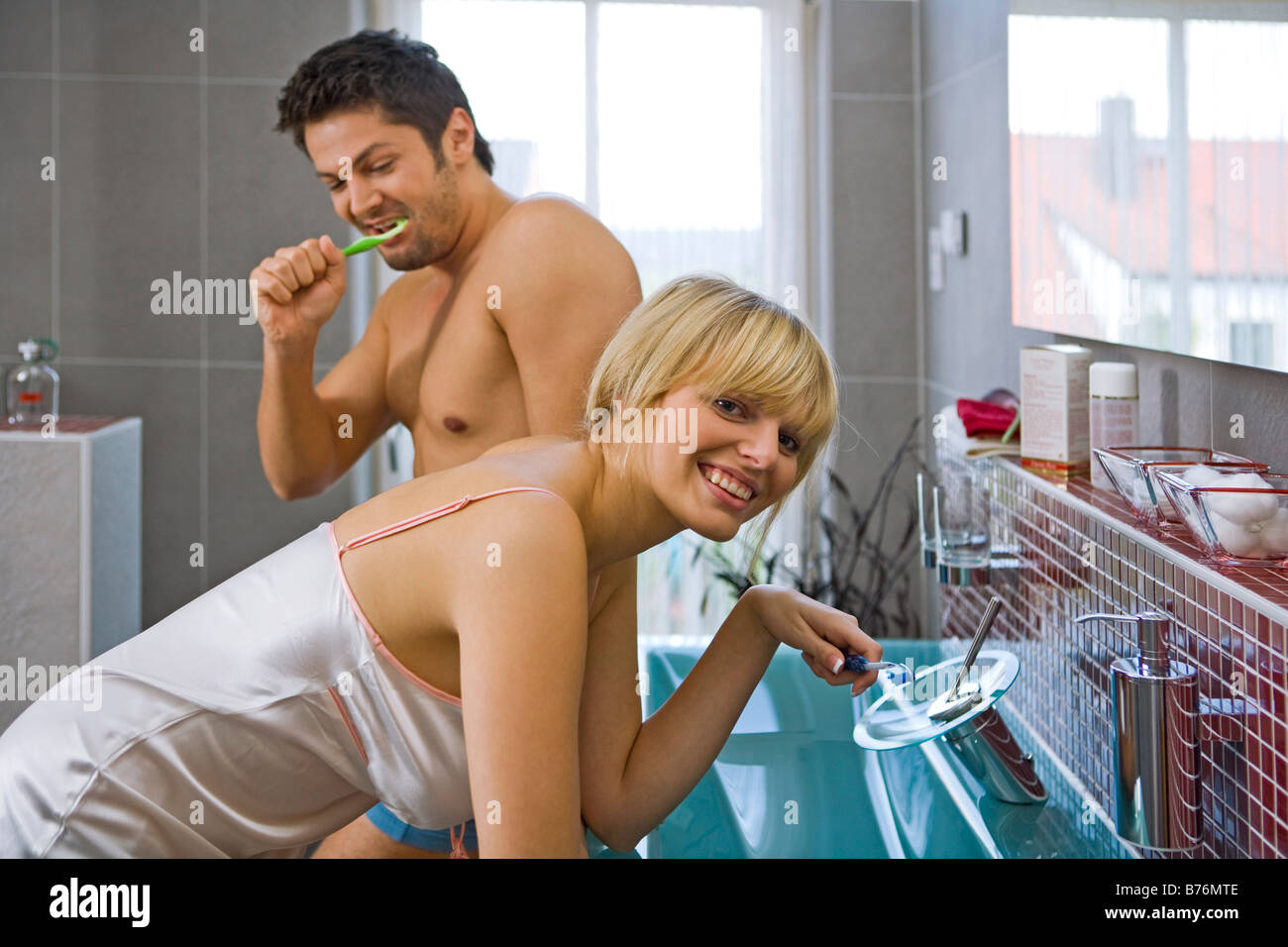 Paar beim Zaehneputzen im Badezimmer, couple with toothbrush in the bathroom Stock Photo