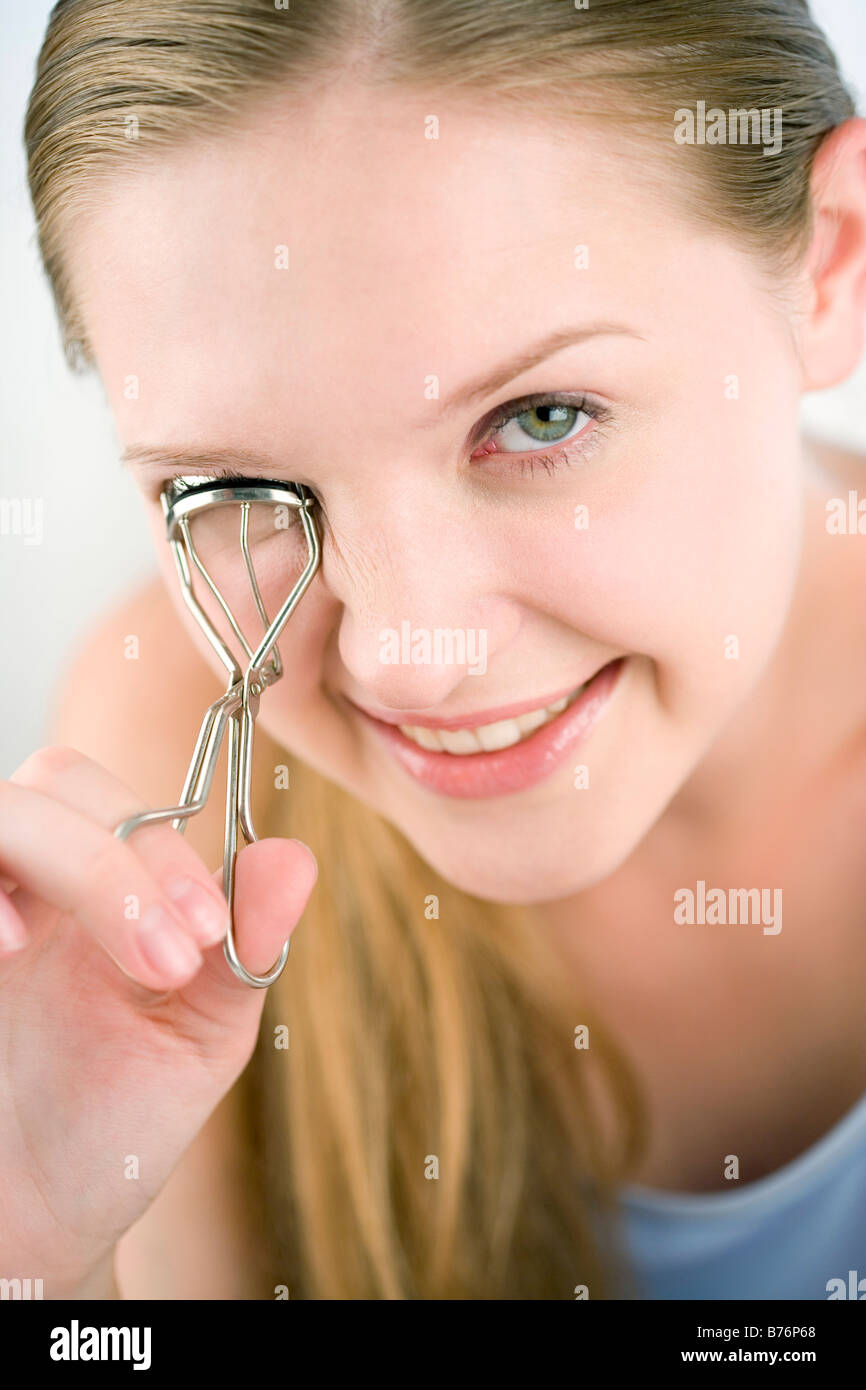 Teenage girl using eyelash curler Stock Photo Alamy