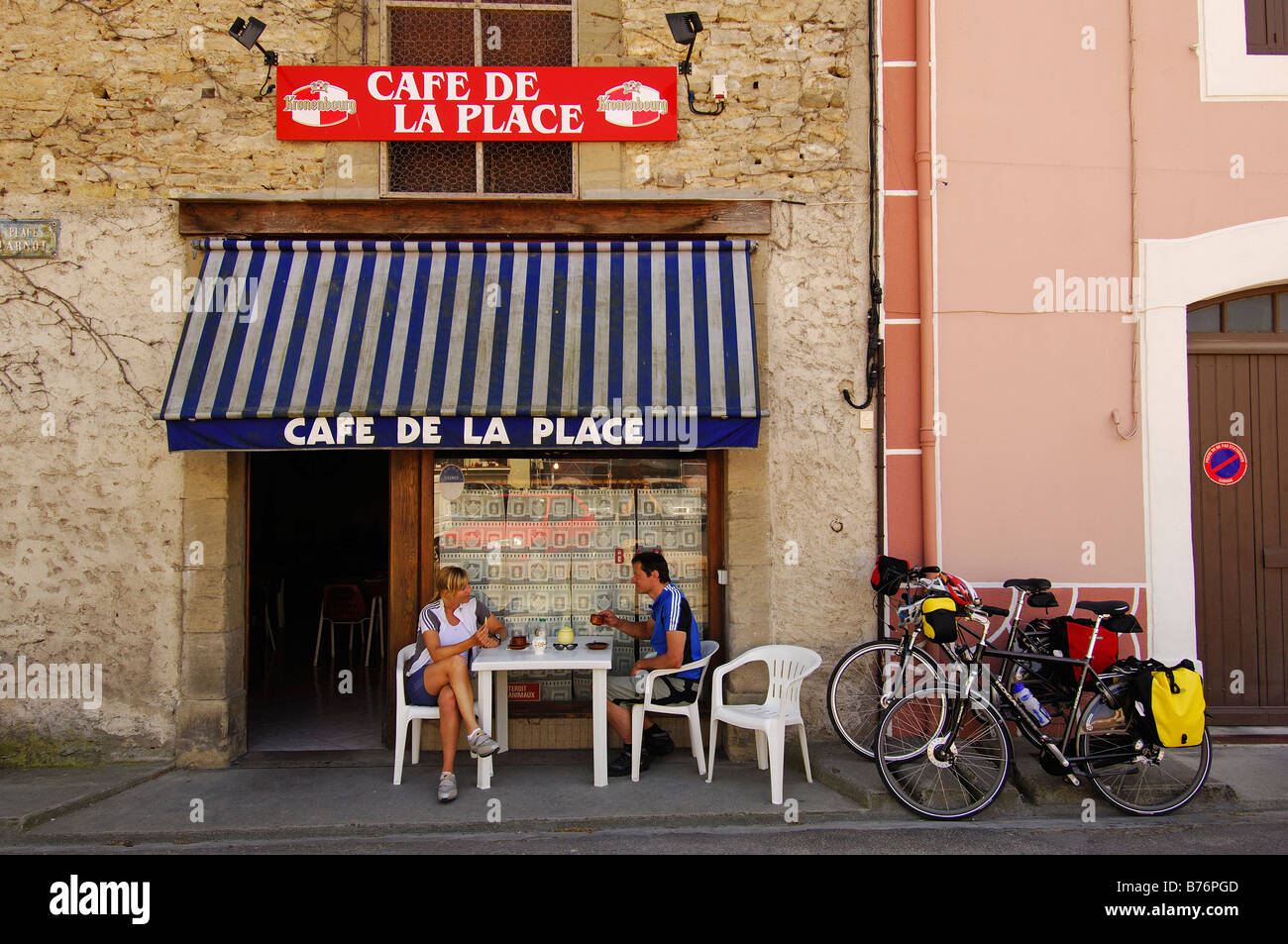 biker at the Cafe de la Place Homps at Canal du Midi MR Stock Photo