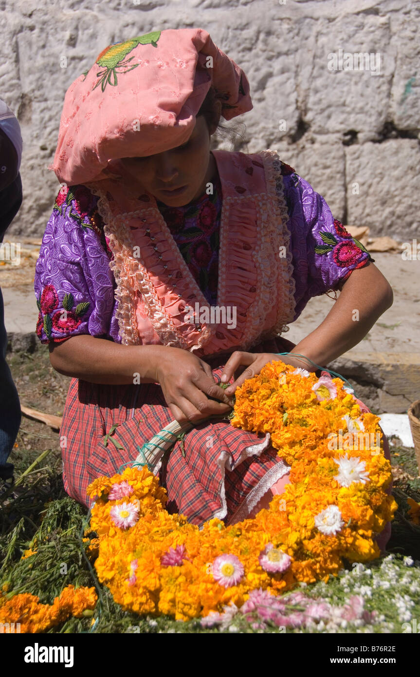 Maya woman creating a marigolds coronet for people who visit the cemetery on november 2nd (All Souls Day). Guatemala. Stock Photo