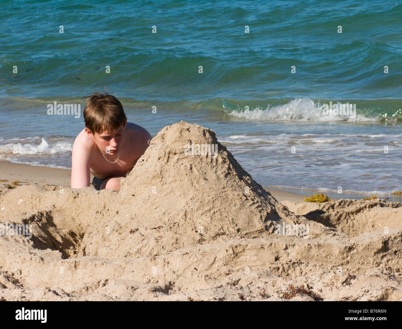 Young boy building sandcastle on beach, Florida, USA Stock Photo