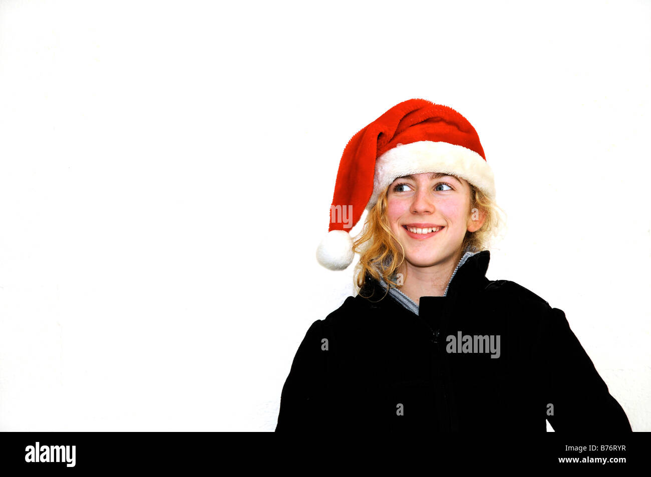 pretty teenager with santa hat agains white background Stock Photo