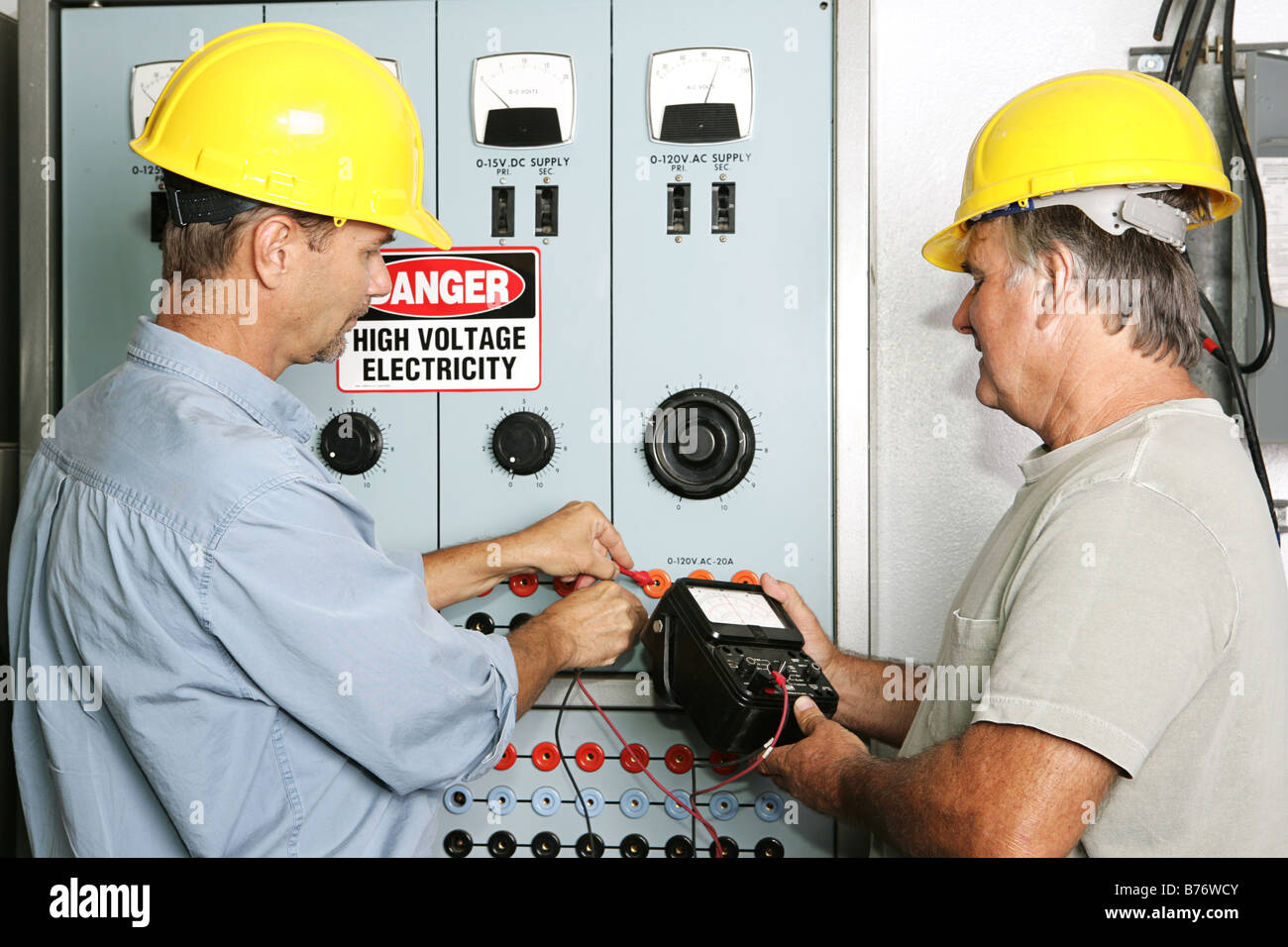 Electricians measuring the voltage output on an industrial power