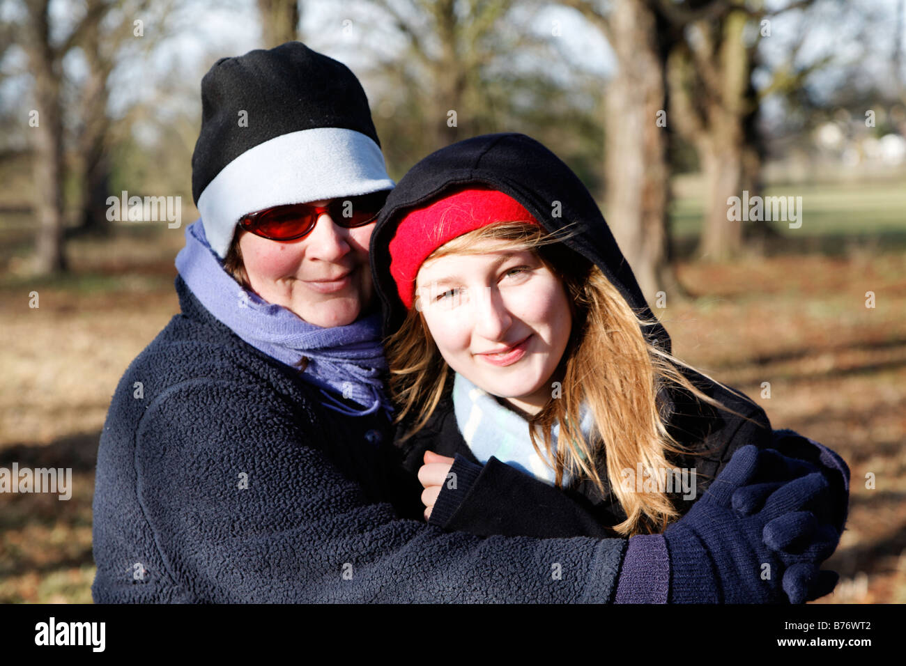 Model Released Mother and daughter portrait on winter walk wearing warm clothes hat and scarf Stock Photo