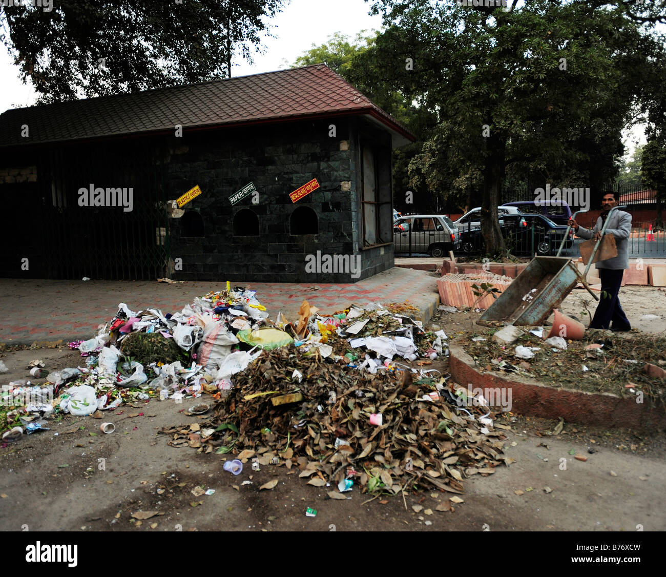 a man dumps rubbish outside a recycling bank Bhagwan Dass Rd New Delhi Stock Photo