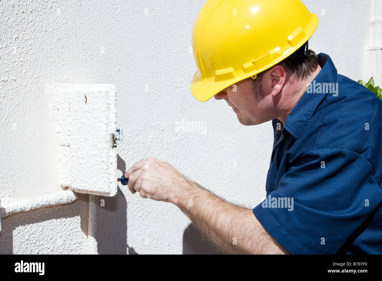 Electrician doing repairs inside and electrical box on the outside of a home Model is a licensed