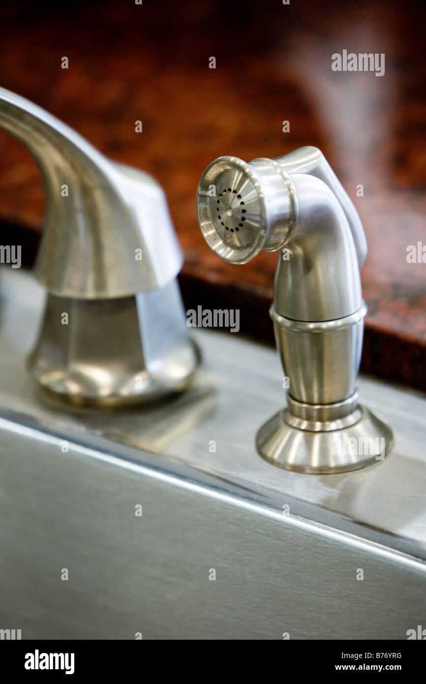 Stainless steel kitchen sink faucet and sprayer Stock Photo