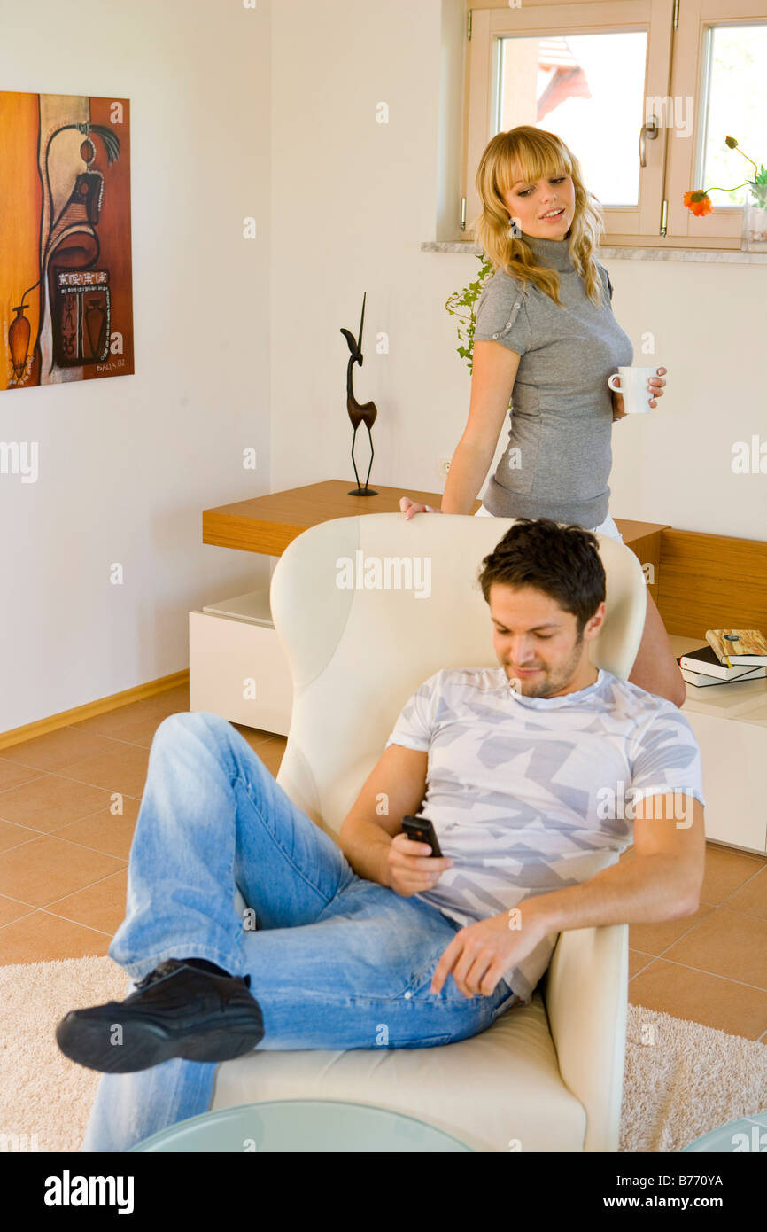 Mann schreibt heimlich SMS, man looking secretly at mobile, woman overlooking Stock Photo