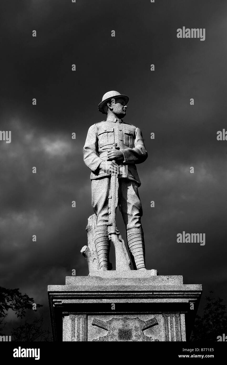 A statue of a first world war soldier dramatically lit against an ominous stormy sky Stock Photo