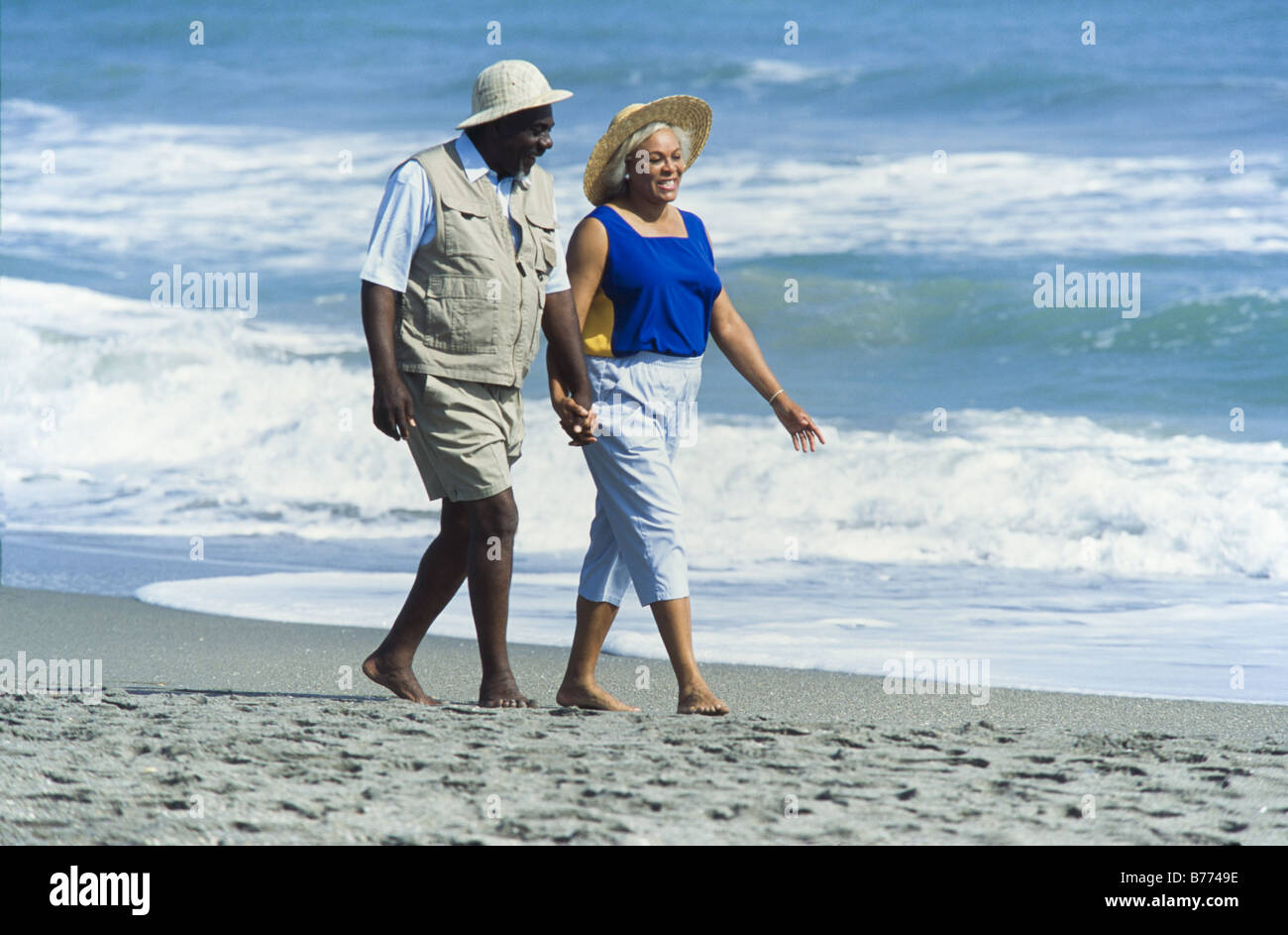 Seniors relaxing together, walking on beach, Miami Stock Photo