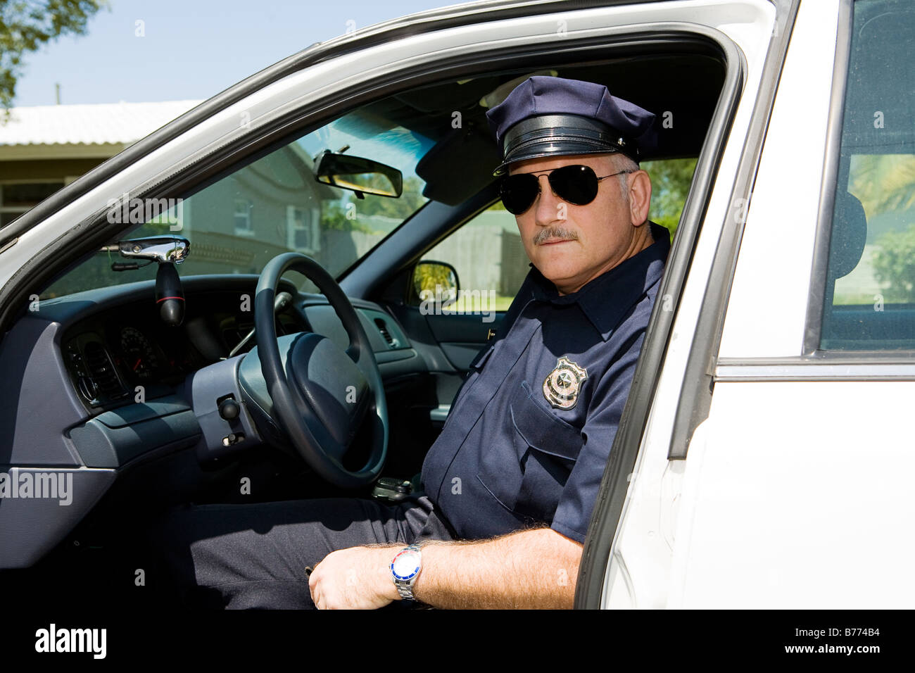 Handsome mature police officer on duty sitting in his squad car Stock ...