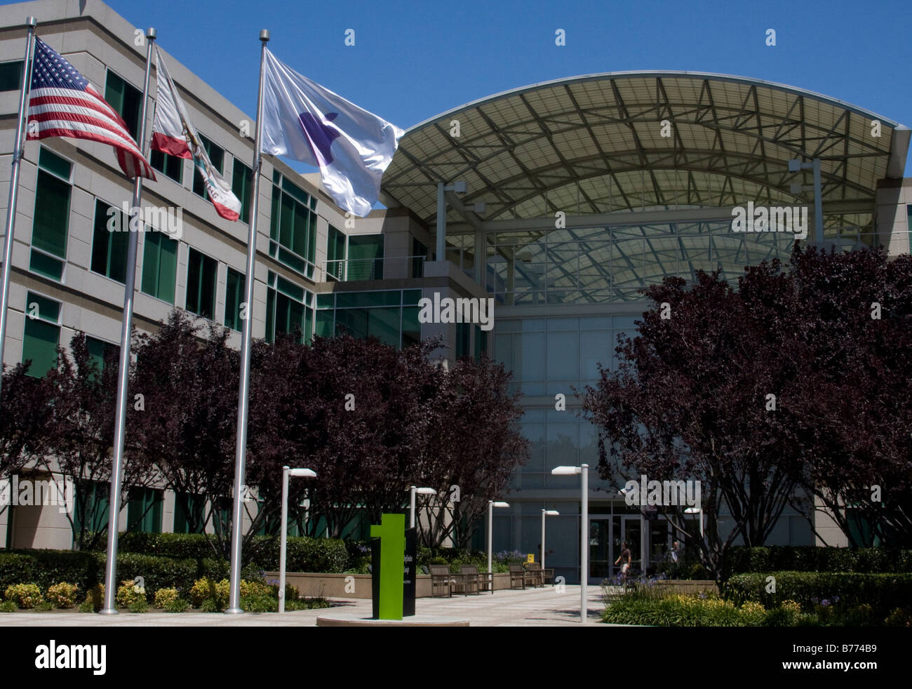 Apple, Inc. headquarters building, Cupertino, Santa Clara County, California, USA.  Shows flags in front, inc. Apple flag. Stock Photo