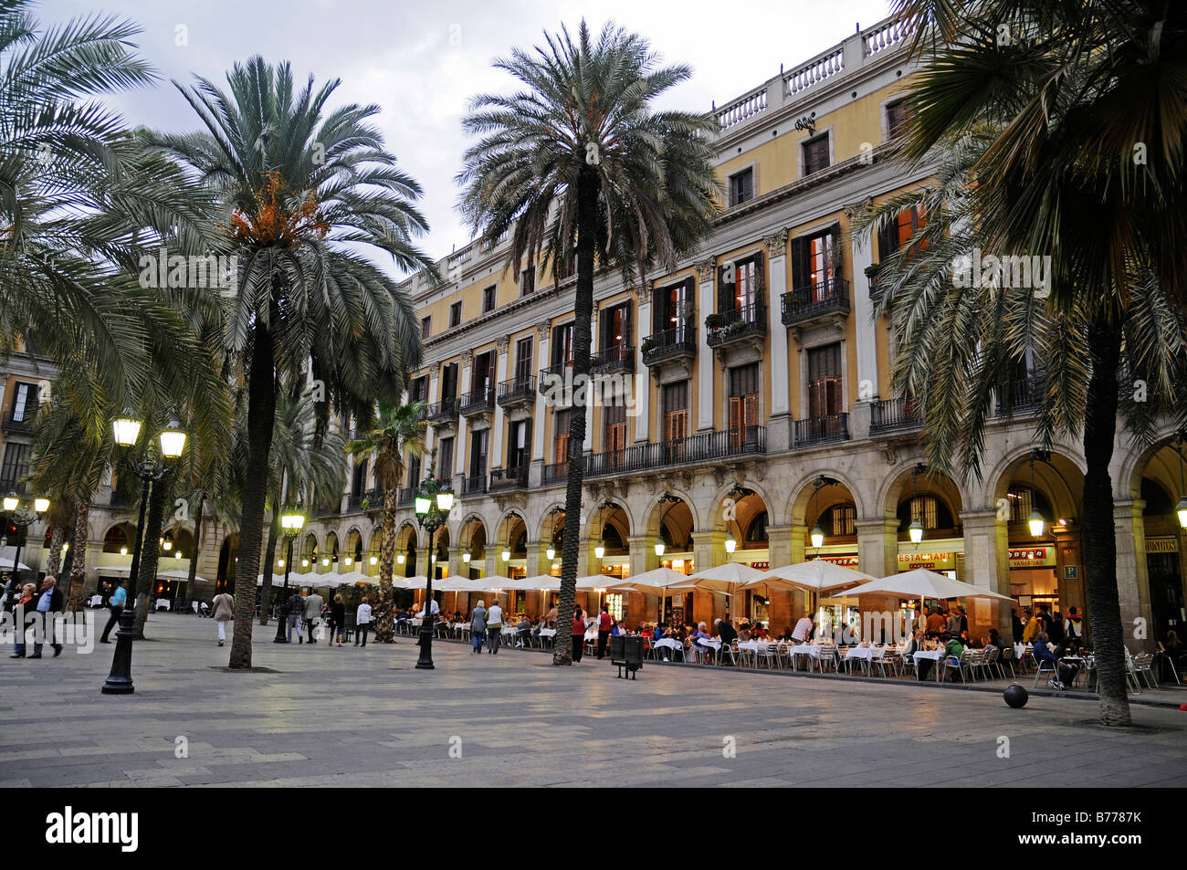 Placa Reial Square, people, palm trees, restaurant, outdoor cafe, dusk, evening, Barcelona, Catalonia, Spain, Europe Stock Photo