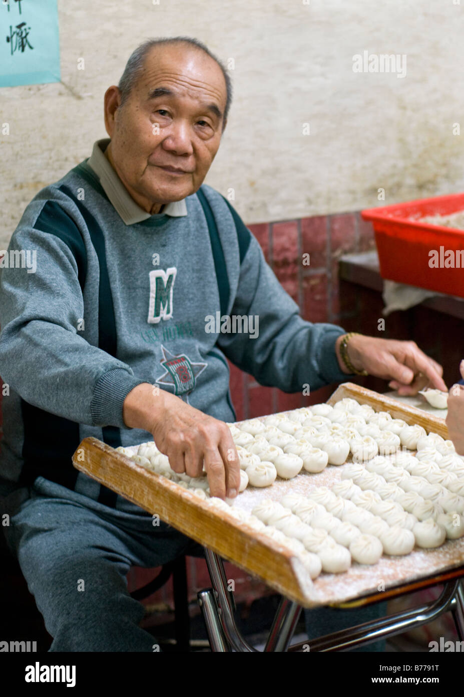 elder family member helping to prepare dumplings in the family breakfast shop in Taipei, Taiwan Stock Photo