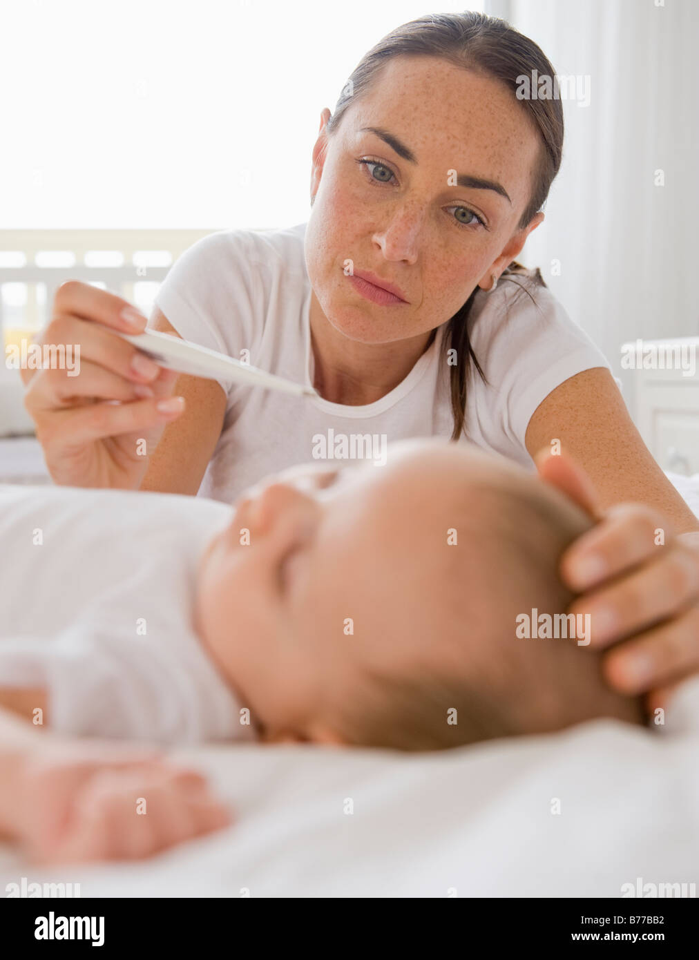 Worried mother checking baby son’s temperature Stock Photo Alamy