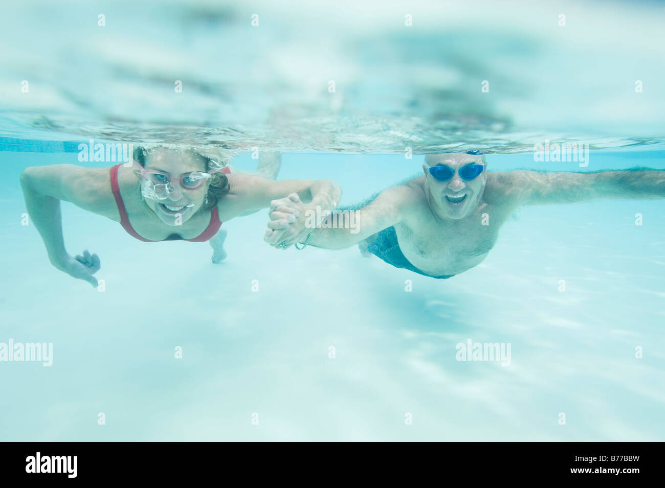 Couple swimming underwater and holding hands Stock Photo Alamy