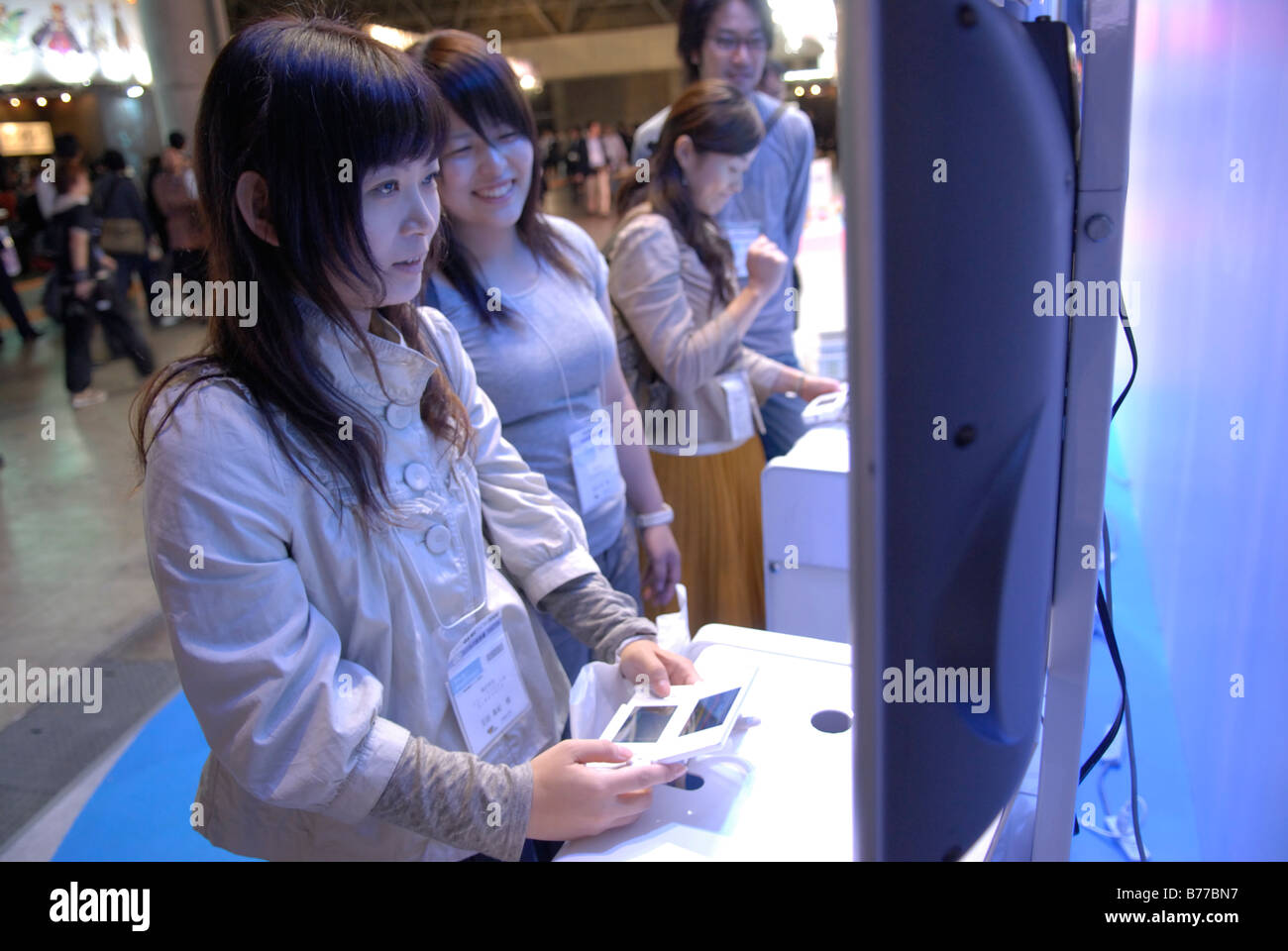 Game show visitors play with a Nintendo DS at the Tokyo Game Show 2008, Tokyo, Japan. Stock Photo