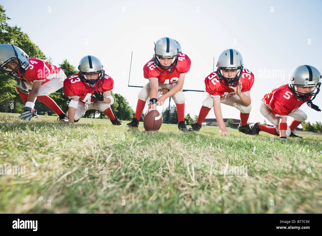 Football players line of scrimmage ready to snap football Stock Photo